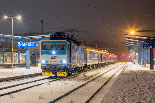 Train R 974 &ldquo;Vysočina&rdquo; on line R9 arrives at the snow-covered railway station in Žď&aacute;r nad S&aacute;zavou. The scene captures the frosty atmosphere of the Vysočina Region (Kraj Vysočina).