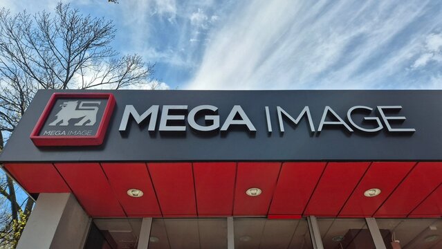 Exterior shot of a Mega Image supermarket storefront with a lion logo and clear blue sky background taken on Aprin 7, 2026 in Bucharest, Romania.