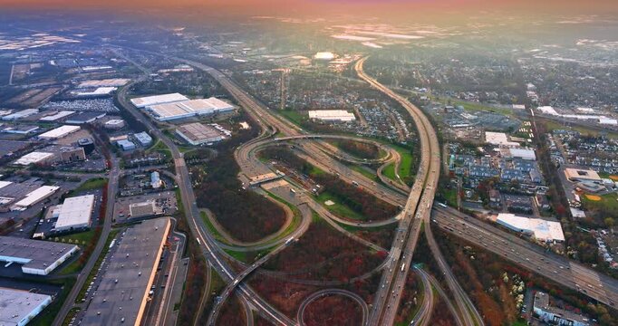 New York city outskirts with a huge interchange. Hundreds of cars move by the motorways. Aerial view.
