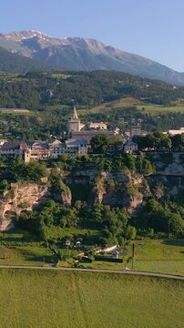 Summer aerial view of Embrun and its famous cliff top plateau in Durance Valley. Hautes-Alpes, French Alps, France