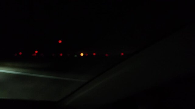 Blurred Red Lights of Airplane Tower Seen While Driving at Night