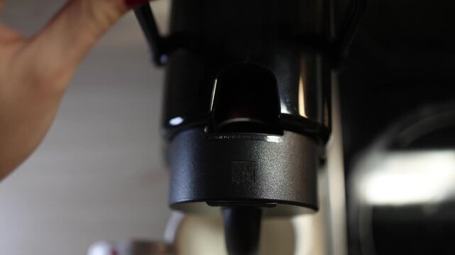 Hand opening coffee machine inserting capsule and closing lid close up preparation process modern kitchen appliance coffee routine and morning lifestyle concept