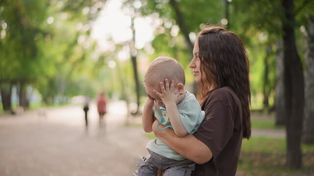 Mother calms child. Neighbor helps distressed young girl. Parent interacts warmly during outdoor community gathering. Mother offers reassurance as neighbor responds with kind gesture during outing