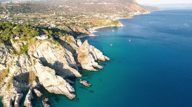 Breathtaking summer aerial panorama of Calabria's Capo Vaticano coastline, showcasing dramatic white cliffs plunging into the crystal-clear turquoise waters