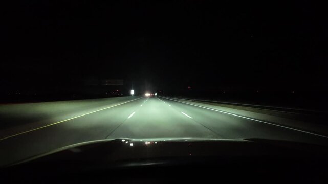Vehicle Travels Down an Empty Highway at Night