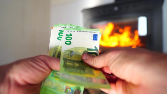 Heating payment. Save money wood stove. Euro money banknotes for payment of heating firewood. Budget wood heat home. Euro money pay for heating costs in heating season. Heat house in European Union EU