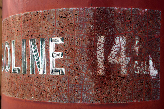 Rusted gasoline tank with vintage lettering detail