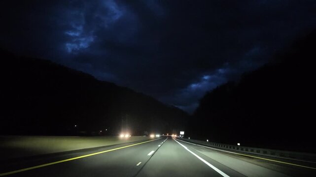 Driving on Curved Appalachian Roads at Night Under Cloudy Sky