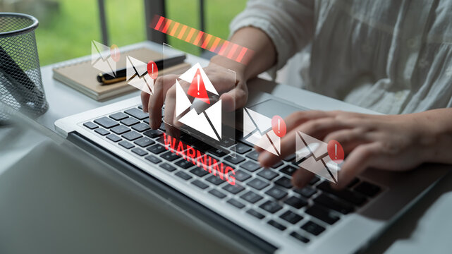 Close-up of hands typing on a laptop keyboard with digital email alerts and warning graphics, highlighting communication and online security in modern workspaces. Gantry