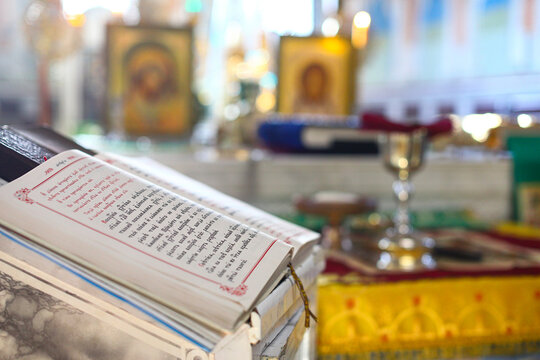 Open Gospel in Old Church Slavonic. Church utensils for communion in the Orthodox church: chalice, prosphora and liturgical bread on the altar. The concept of Orthodoxy