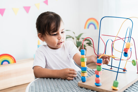 Hispanic little girl playing with development toys at pre school classroom - Kindergarten education smart games for children