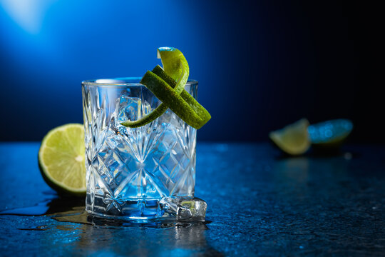 Vodka with lime and ice cubes in a fogged up glass.