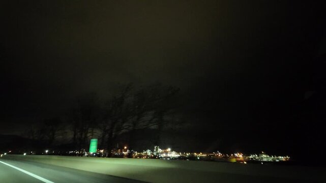Driving Through a Small Town With Bright Lights at Night