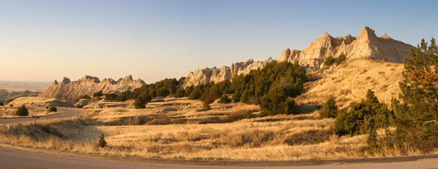 A panoramic view of a rocky ridge in the Badlands of South Dakota at sunset on a clear evening © Daniel Thornberg