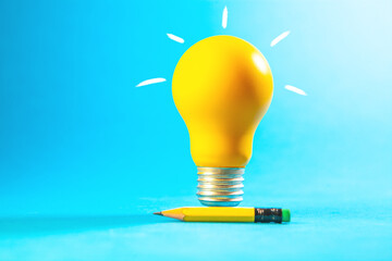 Yellow light bulb with pencil on blue background. Business idea concept. © Artvibe