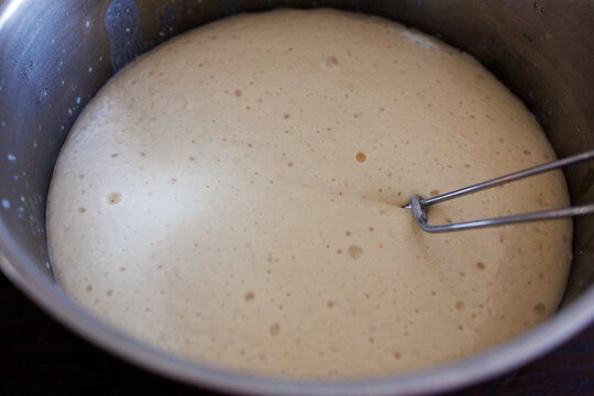 Close up of rising yeast dough with bubbles, fermentation process in homemade baking