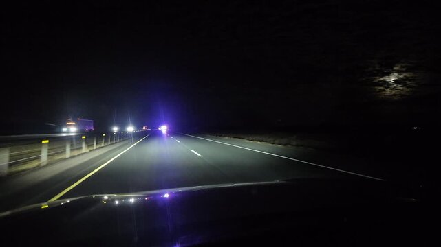 Vehicle Approaches Police Officers on Highway at Night