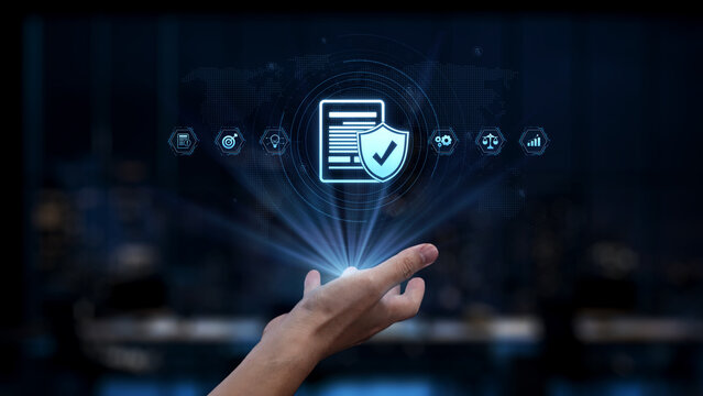 This image depicts a hand reaching out towards a 3D representation of a shield symbolizing data protection and cybersecurity in a modern digital landscape. Synapse