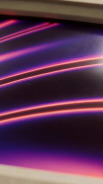 Vertical video: Shifting camera showing monitor with pale bezel on desk, revealing purple bands