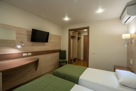Cozy twin bedroom in a modern hotel with wooden furniture and green accents