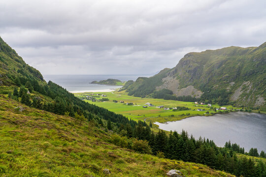Panoramic view of Refvik valley with white sand beach and lake, Norway