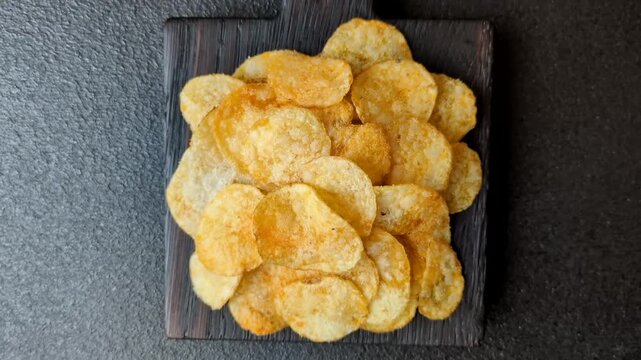 Crispy potato chips, golden slices seasoned with salt and spices. Potato chips as a food background for your design