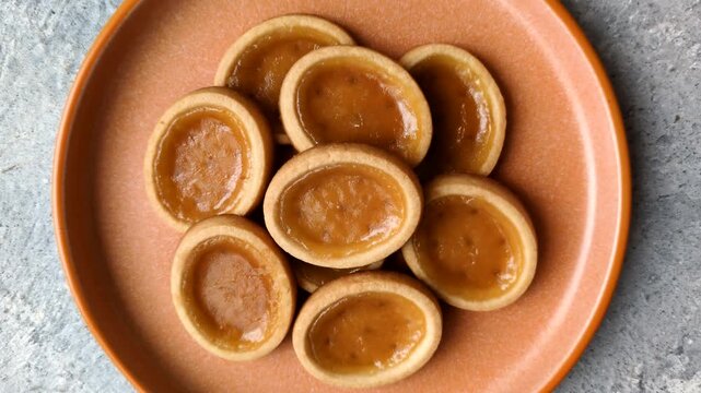 Round mini tartlets with citrus or peach jam and crumbly pastry. Mini citrus tarts as a food background for your design
