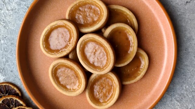 Round mini tartlets with citrus or peach jam and crumbly pastry. Mini citrus tarts as a food background for your design