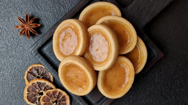 Round mini tartlets with citrus or peach jam and crumbly pastry. Mini citrus tarts as a food background for your design