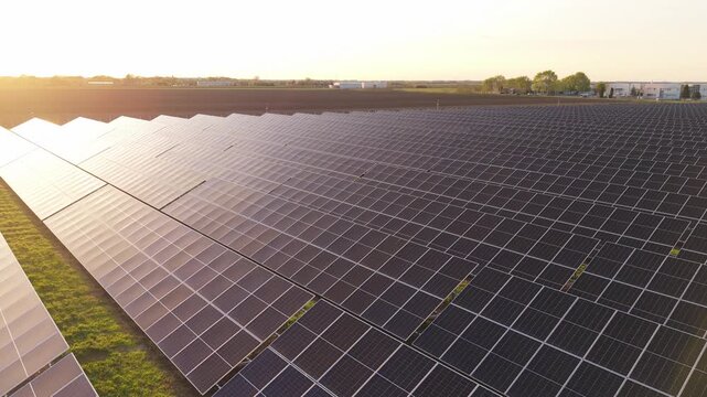 Aerial View of Photovoltaic Solar Panels Rows at Golden Hour Energy Farm
