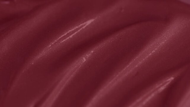 Macro shot of glossy red cosmetic lipstick texture applicator