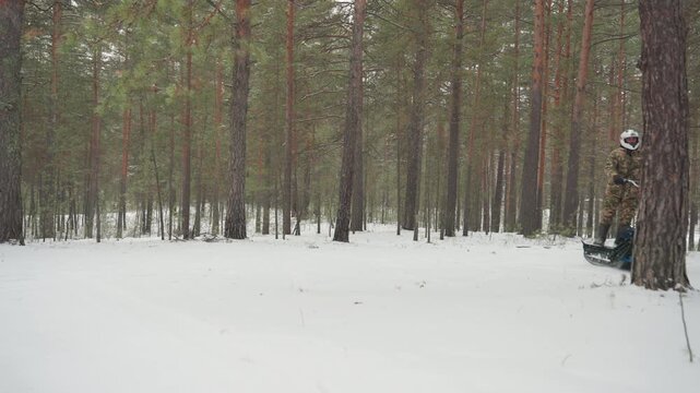 Snowy pine atv carve and recover rider leans into sharp turn, snow spray and flying flakes, dynamic balance on blue tracked atv, standing posture, throttle control, brief tip and quick recovery,