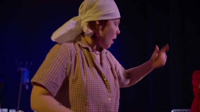 Theatrical performance with passionate actors in period costumes holding red flags on a dramatic stage, expressing emotion through symbolic gestures and movement