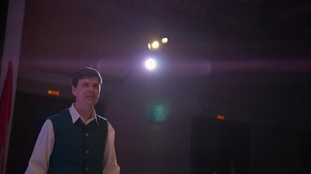 Nervous young performer on stage in dramatic spotlight resolving tension with an emotional embrace during a heartfelt theatrical school play scene