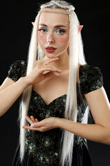 Obraz premium Beautiful girl dressed as elf on black background