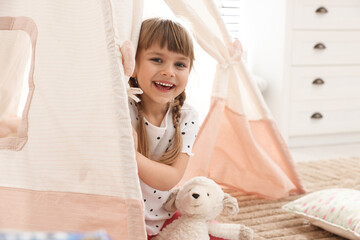 Little girl in toy wigwam at home © New Africa