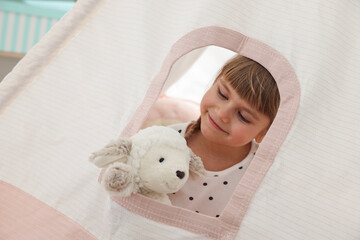 Little girl with toy sheep in wigwam at home © New Africa