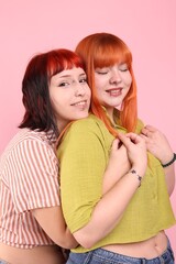 Lovely lesbian couple on pink background. LGBT concept