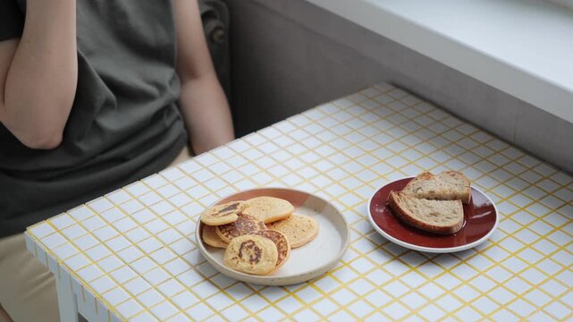 woman eats flatbread pancakes, drinks coffee. vegetarian diet for body health, cooking. person eats breakfast or lunch in the kitchen. delicious and healthy food cooked at home. high quality 4k video