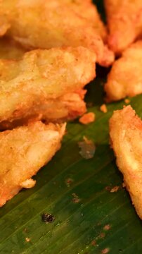 Fried platanos on plate. Sliced and cooked tostones. Rotating. Vertical footage