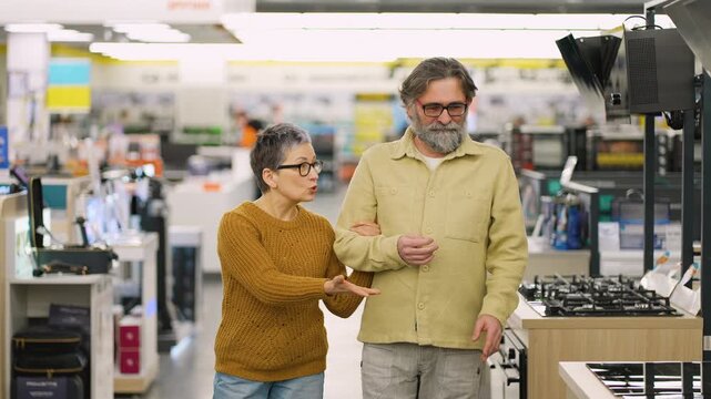 Mature couple shopping for appliances in electronics store