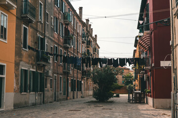 First-person perspective from a gondola navigating a narrow Venetian canal, framed by historic buildings and an arched stone bridge in Venice, Italy. © Maria Sap