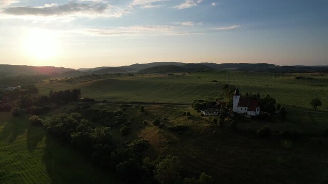 Remote Church of Saint Lawrence at Zdoun in Sumava mountains with cemetery captured as aerial panorama historic religious landmark
