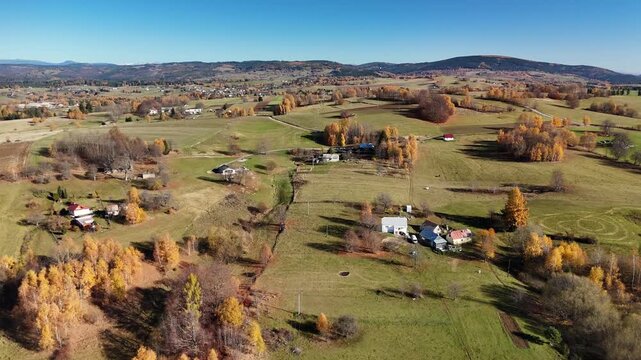Aerial view of rolling green fields and hills in the distance, with a winding road cutting through, Detvianska Huta, Banska Bystrica Region, Slovakia.