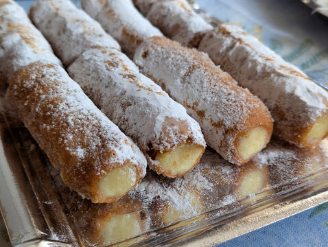 Traditional cream-filled pastry rolls known as canutillos, a typical sweet dessert from Zamora, coated with powdered sugar and served on a tray, Castile and Le&oacute;n, Spain.
