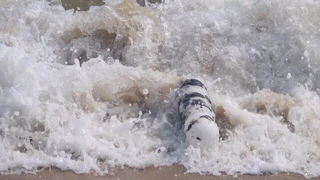 Oil pollution of sea, coast. Floating objects (flotsam, trawl float) are covered with fuel oil and bring toxin to other parts of sea, secondary pollution. Sandy beach attacked by fuel. South China Sea