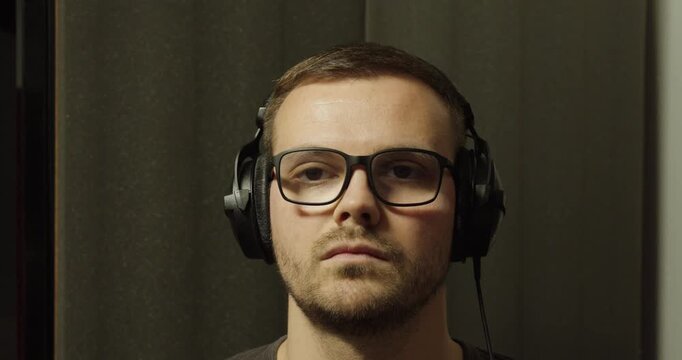 Man Putting On and Taking Off Headphones in Soundproof Room &ndash; Audio Isolation Test