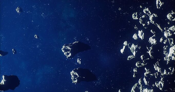 A vast expanse of deep space is filled with numerous asteroids drifting silently among stars. The scene highlights the diverse shapes and sizes of these celestial bodies.