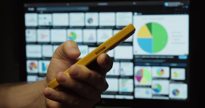 Hand Holding Smartphone with Business Data Dashboard &ndash; Mobile Technology Concept