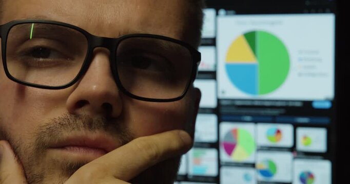 Serious Businessman Watching Analytics Data on Screens &ndash; Close-Up Portrait
